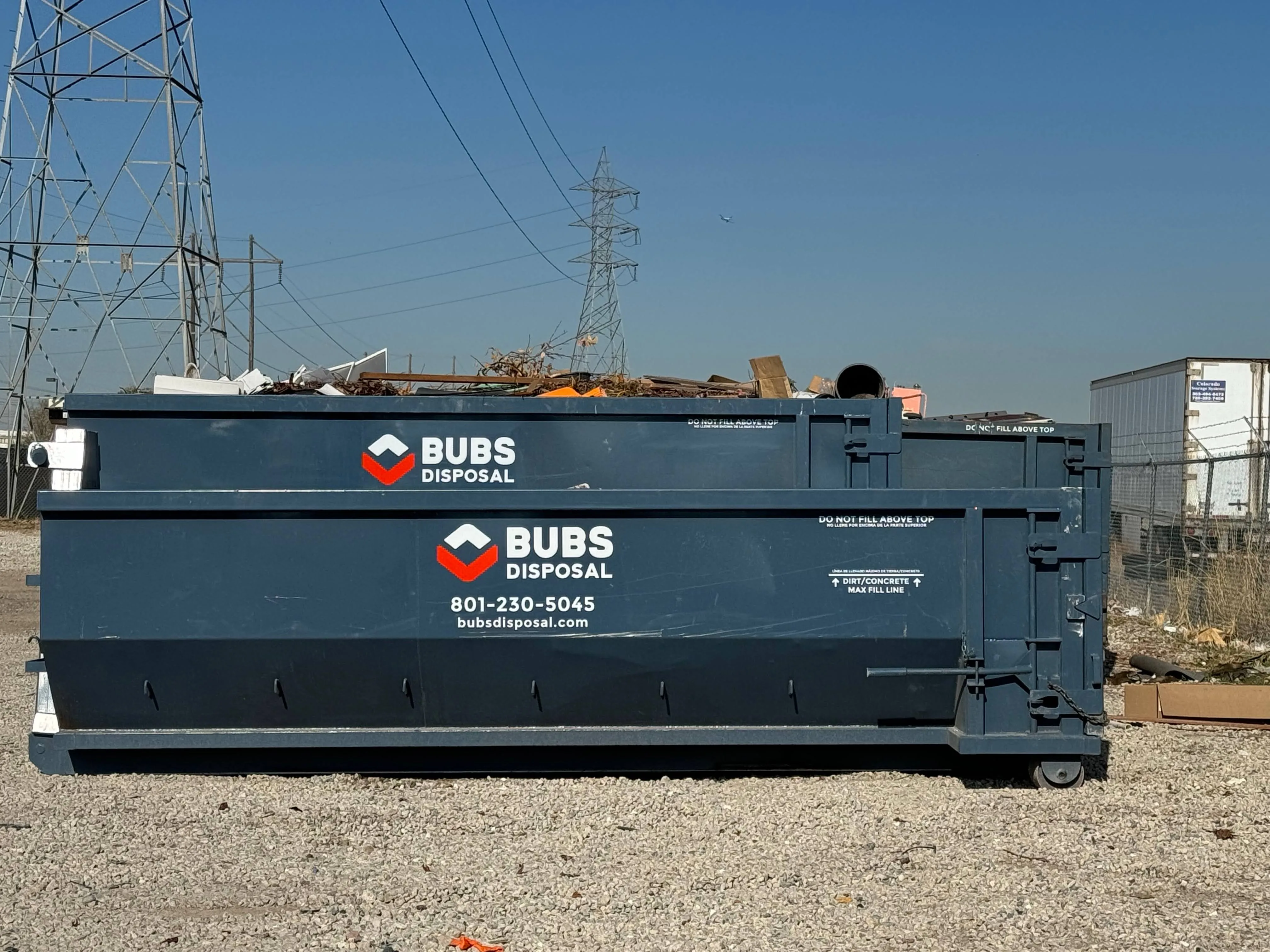 Closeup of a Bubs Disposal 30 yard dumpster with branding and a full load