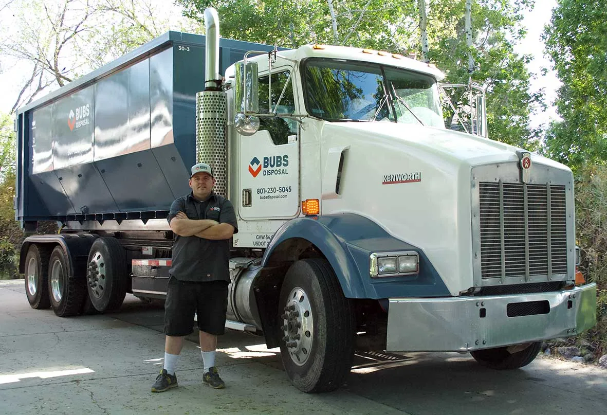 Bubba standing in front of a Bubs Disposal Kenworth roll-off truck