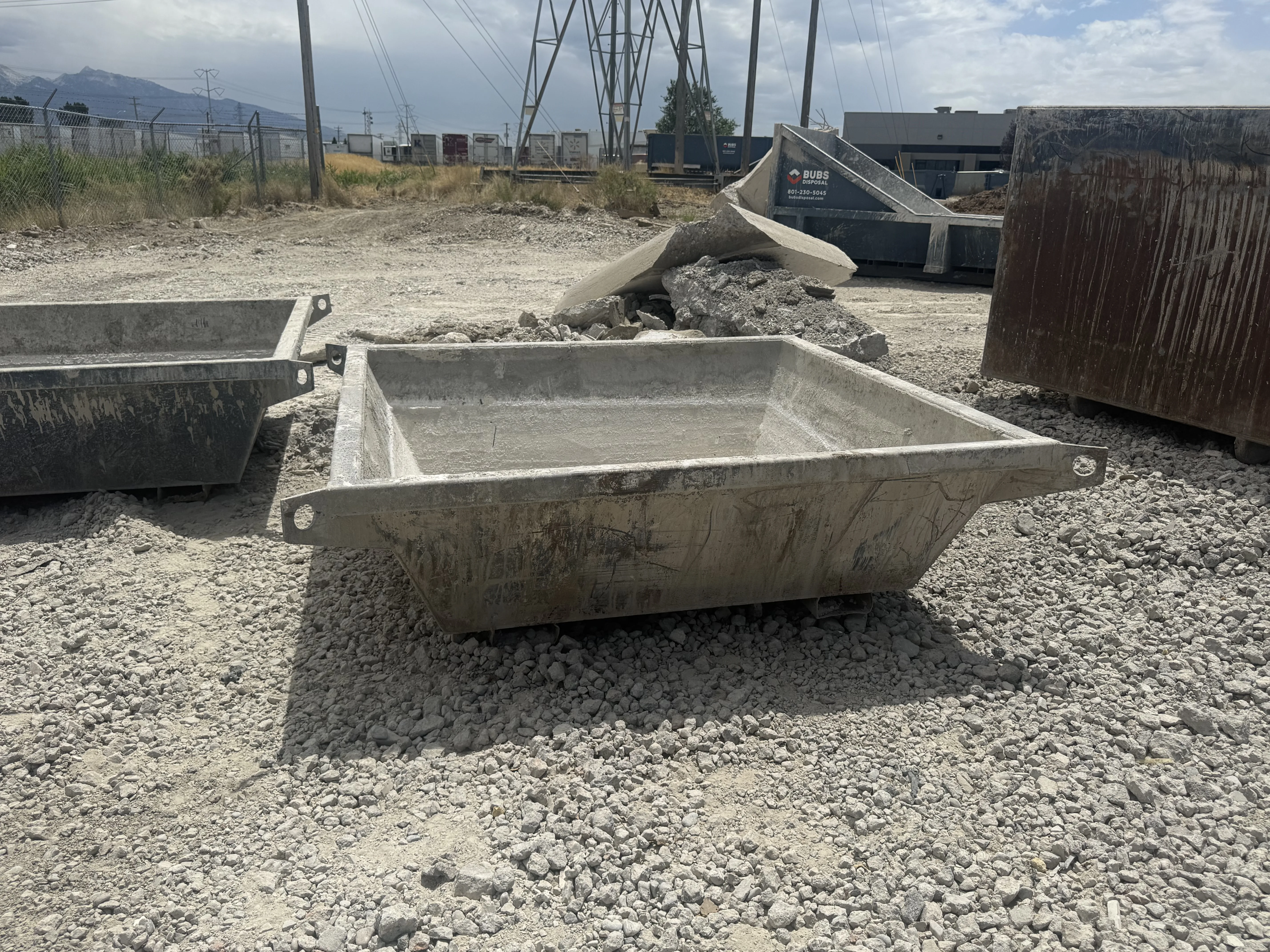 1.5 yard concrete washout pan loaded with debris
