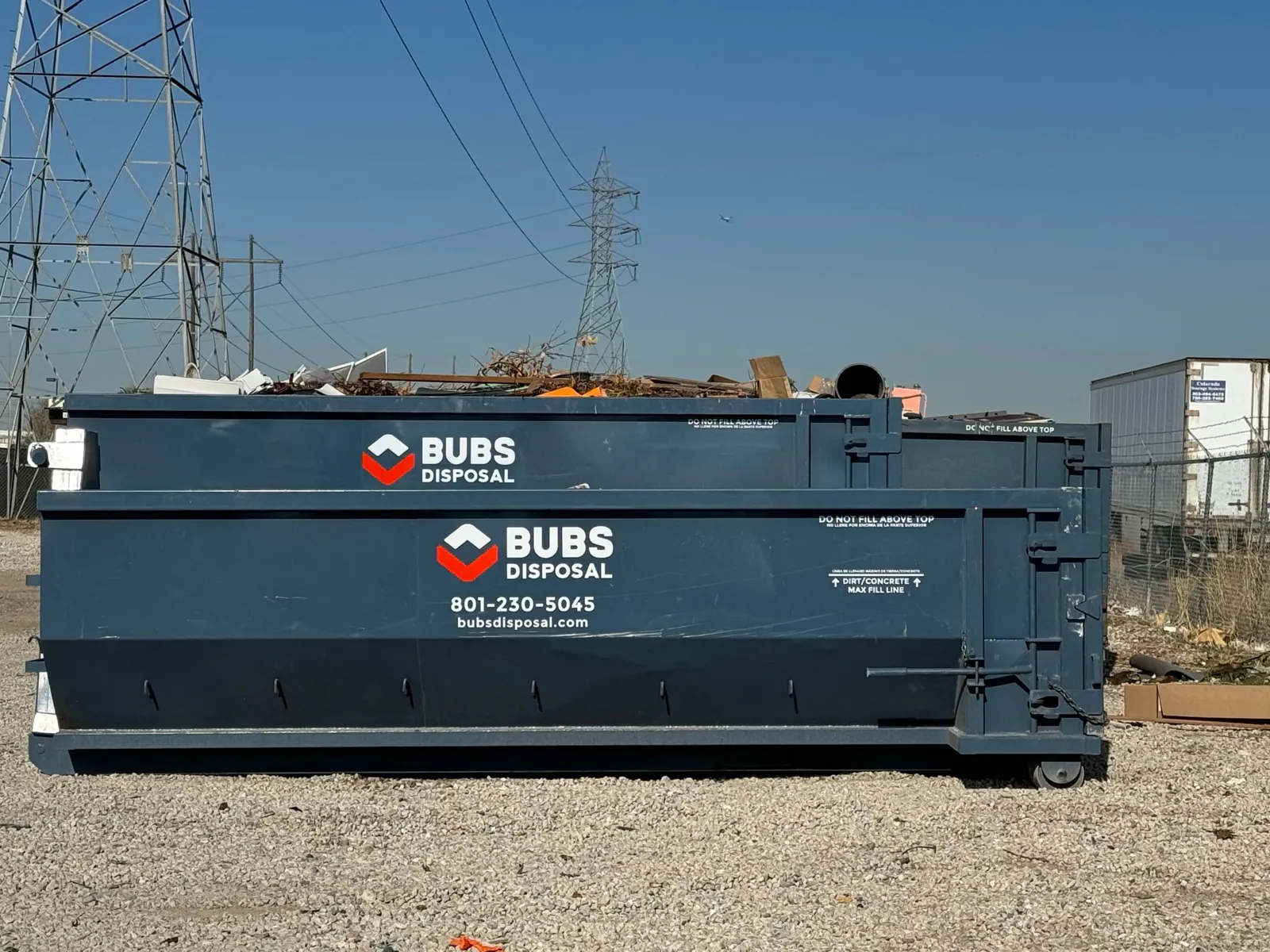 Closeup of a Bubs Disposal 30 yard dumpster with branding and a full load