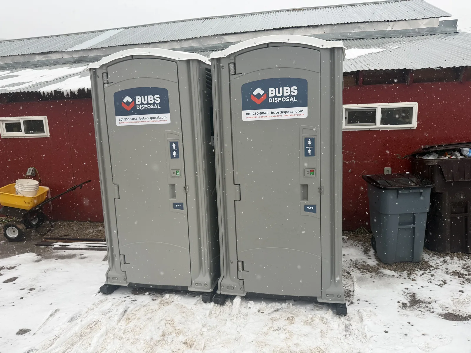 Two Bubs Disposal portable toilets set out in falling snow